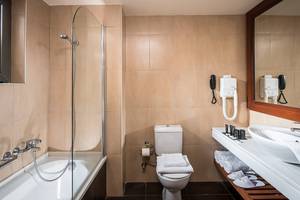 Badezimmer im Stella Palace Resort & Spa mit Badewanne, Dusche, Toilette und Waschbecken.
