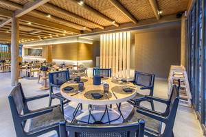 Innenbereich des Stella Palace Resort & Spa, modernes Restaurant mit Holzelementen und Glasfenstern.