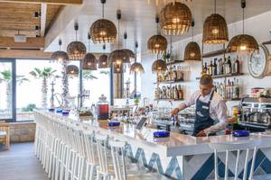 Ein Barkeeper serviert Getränke in der Bar des Stella Palace Resort & Spa.