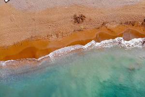 Luftaufnahme des Eftalia Holiday Village Strands und Meeres mit braunem Sand und blauem Wasser