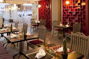 Innenansicht des Restaurants im Paloma Oceana Hotel mit roten Wänden und gedeckten Tischen.