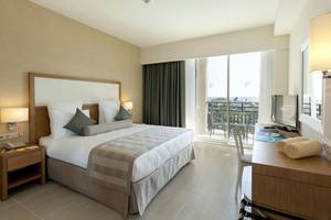 Innenansicht eines eleganten Hotelzimmers im Paloma Oceana Hotel mit großem Bett, Balkon und Meerblick.