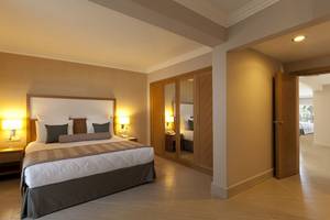 Innenansicht eines Schlafzimmers im Paloma Oceana Hotel mit Doppelbett, Nachttischen und Kleiderschrank.