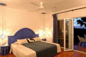 Schlafzimmer im Jardin del Eden Boutique Hotel mit offenem Balkon und Aussicht.