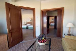 Suite Zimmer im Cascades Golf Resort Spa & Thalasso mit offenem Eingang, Couch, Tisch und Früchtekorb.