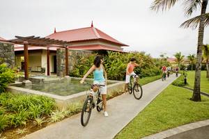 Fahrradfahrer vor dem Tamassa Bel Ombre Hotel am Pool