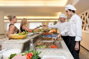 Im HSM Golden Playa Hotel servieren Köche ein Buffet mit verschiedenen Gerichten.
