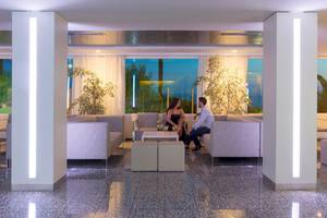 Lobby-Lounge-Bereich des HSM Golden Playa Hotels mit Paar auf Sofas.
