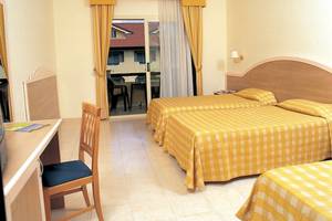 Doppelzimmer mit Balkon im Falkensteiner Club Funimation Garden Calabria, mit zwei Betten und einem Schreibtisch.