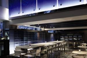 Der Bar- und Loungebereich des Hyatt Grand Central New York mit langen Tischen und Stühlen.