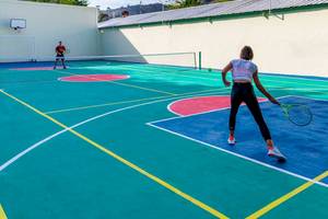 Tennisplatz im Playabachata Spa Resort Hotel mit zwei Spielern, die Tennis spielen.