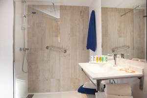 Badezimmer des HSM Golden Playa Hotels mit blauem Handtuch und moderner Einrichtung.