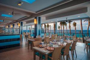 Innenansicht des Restaurants im Riu Cancun mit Blick auf das Meer und Palmen