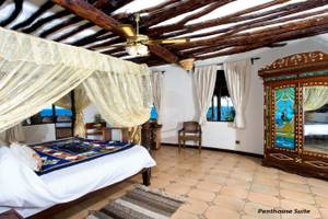 Schlafzimmer im Sands at Chale Island Resort mit Himmelbett, Holzdecke und Meerblick.