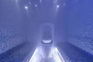 Ein Dampfbad im Astir Beach Hotel auf Kreta mit blauen Fliesen und einer weißen Schüssel.