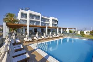 Außenbereich des Astir Beach Hotels auf Kreta mit Swimmingpool und Sonnenliegen.