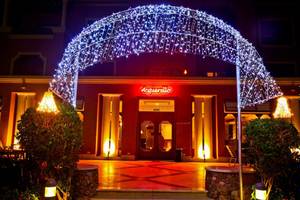 Der beleuchtete Eingang des Charmillion Club Aqua Park Hotels mit einem bogenförmigen Lichtervorhang.