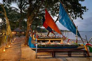 Abendessen auf einem Boot am Strand des Melia Bali Hotels bei Nacht.