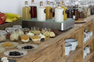 Frühstücksbuffet im Rocabella Mykonos Art Hotel & Spa mit verschiedenen Desserts, Früchten und Getränken.