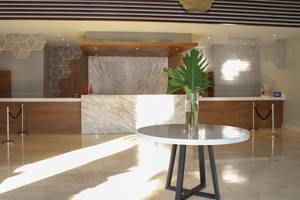Lobby des Casa Marina Beach Resort mit Tisch, Pflanze und Empfangstresen.