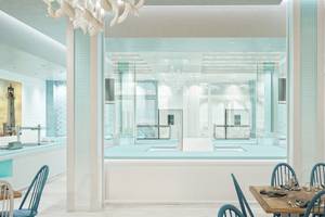 Innendesign des Coral Level im Iberostar Selection Bávaro Hotel mit blauen und weißen Wänden, modernen Möbeln und einer großen Glasfront.