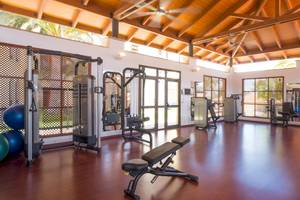 Fitnesscenter im Iberostar Selection Anthelia Hotel mit verschiedenen Trainingsgeräten und blauen Medizinbällen.