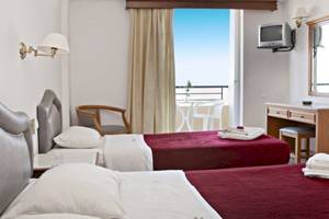 Doppelzimmer im Dedalos Beach Hotel mit zwei Betten, Balkon und Meerblick.