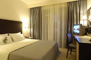 Hotelzimmer im Nana Golden Beach mit Bett, Fernseher und Schreibtisch.