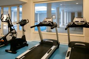 Fitnessgeräte im Louis Paphos Breeze Hotel mit Blick auf den Pool.