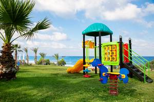 Spielplatz am Strand des Louis Paphos Breeze Hotels mit Blick auf das Meer.