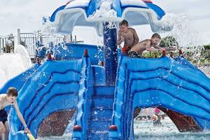 Drei Kinder spielen auf einer blauen Wasserrutsche im Rodos Princess Beach Hotel.