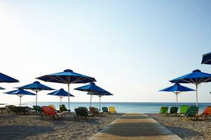Strand mit vielen bunten Liegestühlen und blauen Sonnenschirmen vom Esperides Beach Resort