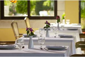 Reservierungstisch im Restaurant des Esperides Beach Resort mit Blumen und Geschirr.