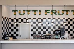 Bar im Hotel Esperides Beach Resort mit schwarz-weißem Schachbrettmuster und 'Tutti Frutti' Schriftzug.
