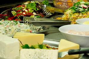 Buffet mit verschiedenen Salaten, Dips, Käseplatten und Obstsalat im Astir Palace Hotel.