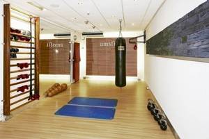 Fitnessraum im NH Amsterdam Centre Hotel mit Boxsack, Hanteln und Trainingsmatten.