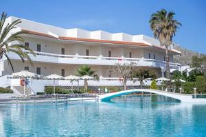 Außenpool des Niriides Beach Hotels mit Umkleidekabinen und Palmenbäumen im Vordergrund