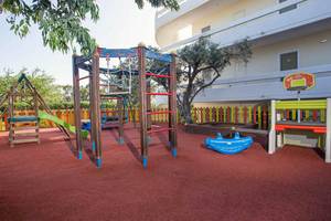 Kinderspielplatz vor dem Niriides Beach Hotel mit Klettergerüst, Rutsche und Basketballkorb.