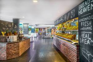 Innenansicht des Restaurants im Asteria Family Resort Belek mit rustikalem Design und Speisenbuffet.