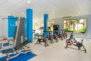Fitnessstudio im VOI Praia De Chaves Resort mit verschiedenen Geräten auf blauen Matten.