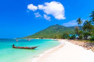 Strand der Anantara Rasananda Koh Phangan Villas mit Booten und Berg