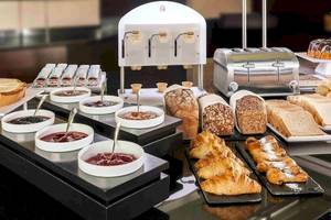 Frühstücksbuffet im NH Hamburg Altona mit Brot, Croissants, Marmeladen und Toaster.