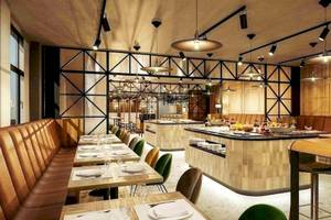 Innenansicht des Restaurants im NH Hamburg Altona mit gepolsterten Bänken und Tischen.