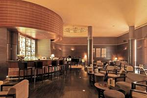 Innenansicht der Bar im Atlas Medina & Spa Hotel mit Bar, Klavier und Sitzmöbeln.