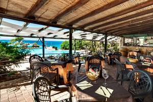 Terrasse des Colonna Grand Hotel Capo Testa mit Blick auf den Pool.