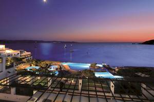 Abendlicher Ausblick auf das Colonna Grand Hotel Capo Testa mit Swimmingpools und Blick auf das Meer