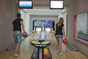 Zwei Personen, ein Mann und eine Frau, stehen in einer Bowlingbahn des Aydinbey Kings Palace & Spa.