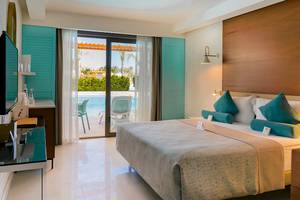 Schlafzimmer im Baia Lara Hotel mit Blick auf den Pool und Außenbereich.