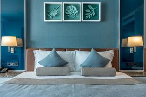 Hotel Baia Lara Schlafzimmer mit blauen Wand und modernem Bett.