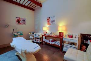 Kosmetikbehandlungsraum im Baia Lara Hotel mit Behandlungsliege, Lampen und Produkten.